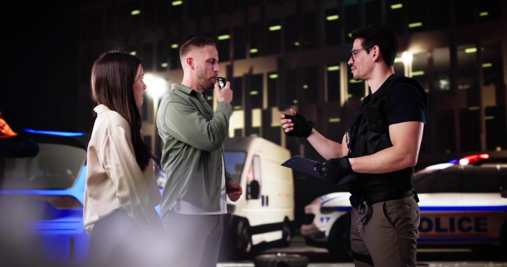 Police Officer Conducts Blood Test At DUI Driving Accident Scene