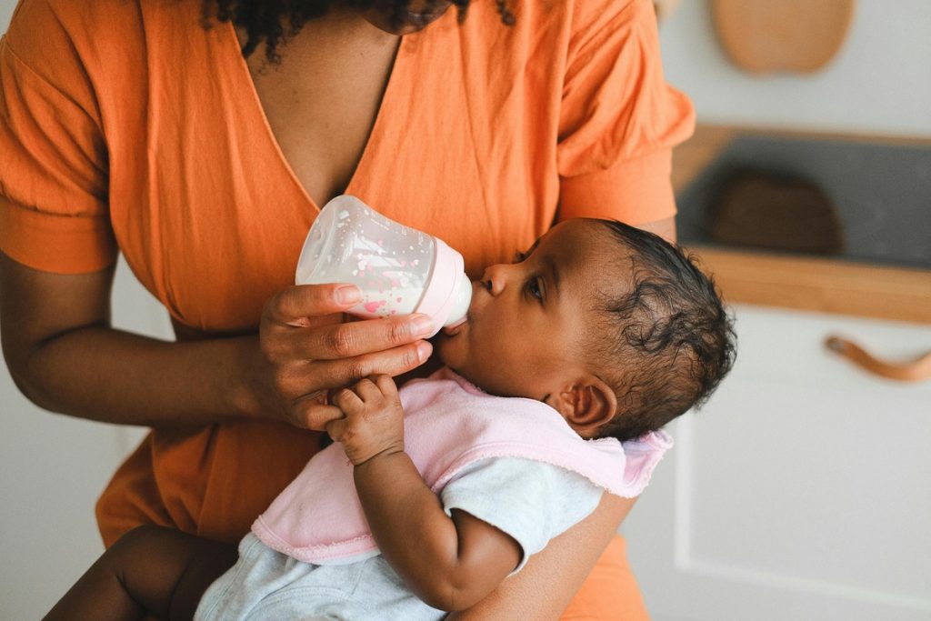 Woman Feeding a Baby with Organic Formula